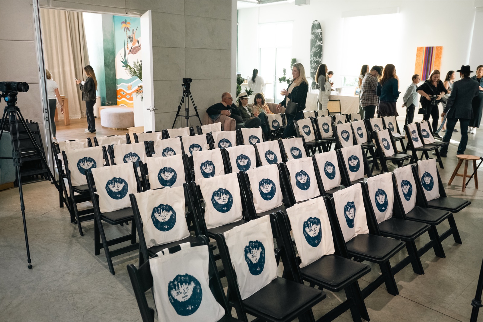 The Clubhouse set with rows of seating and branded totes for a talk