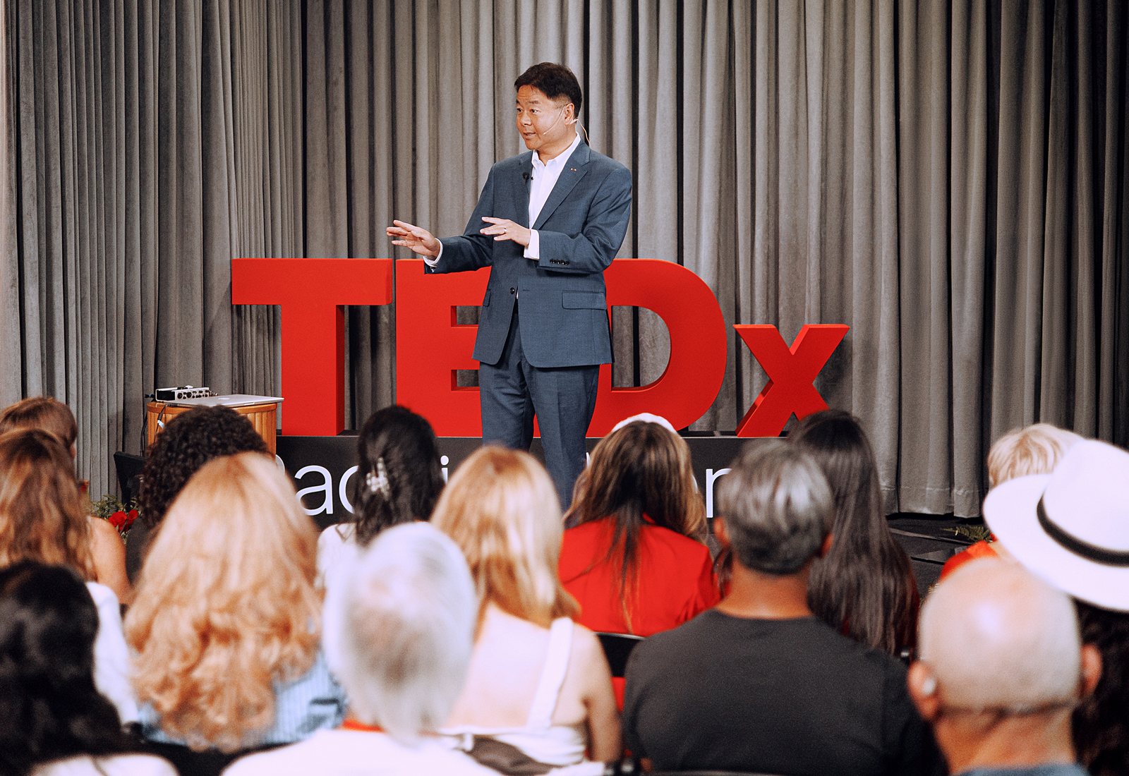 A speaker on stage before a full house at The KINN