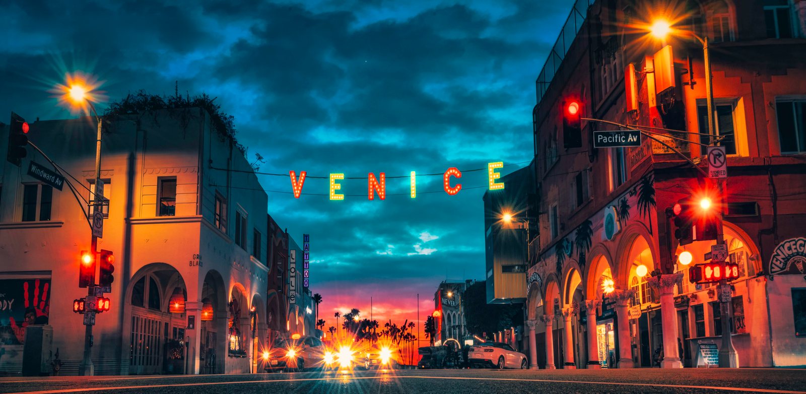 The illuminated Venice sign over Pacific Avenue at dusk